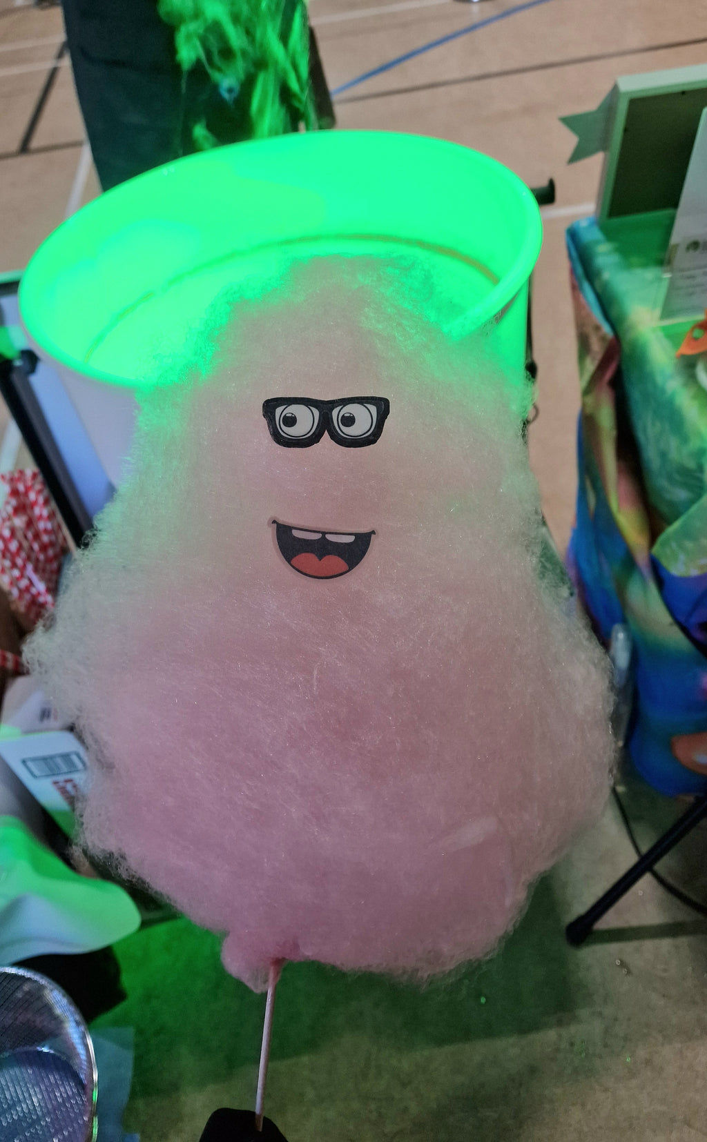 Plush toy with a green hat and face on a colorful background
