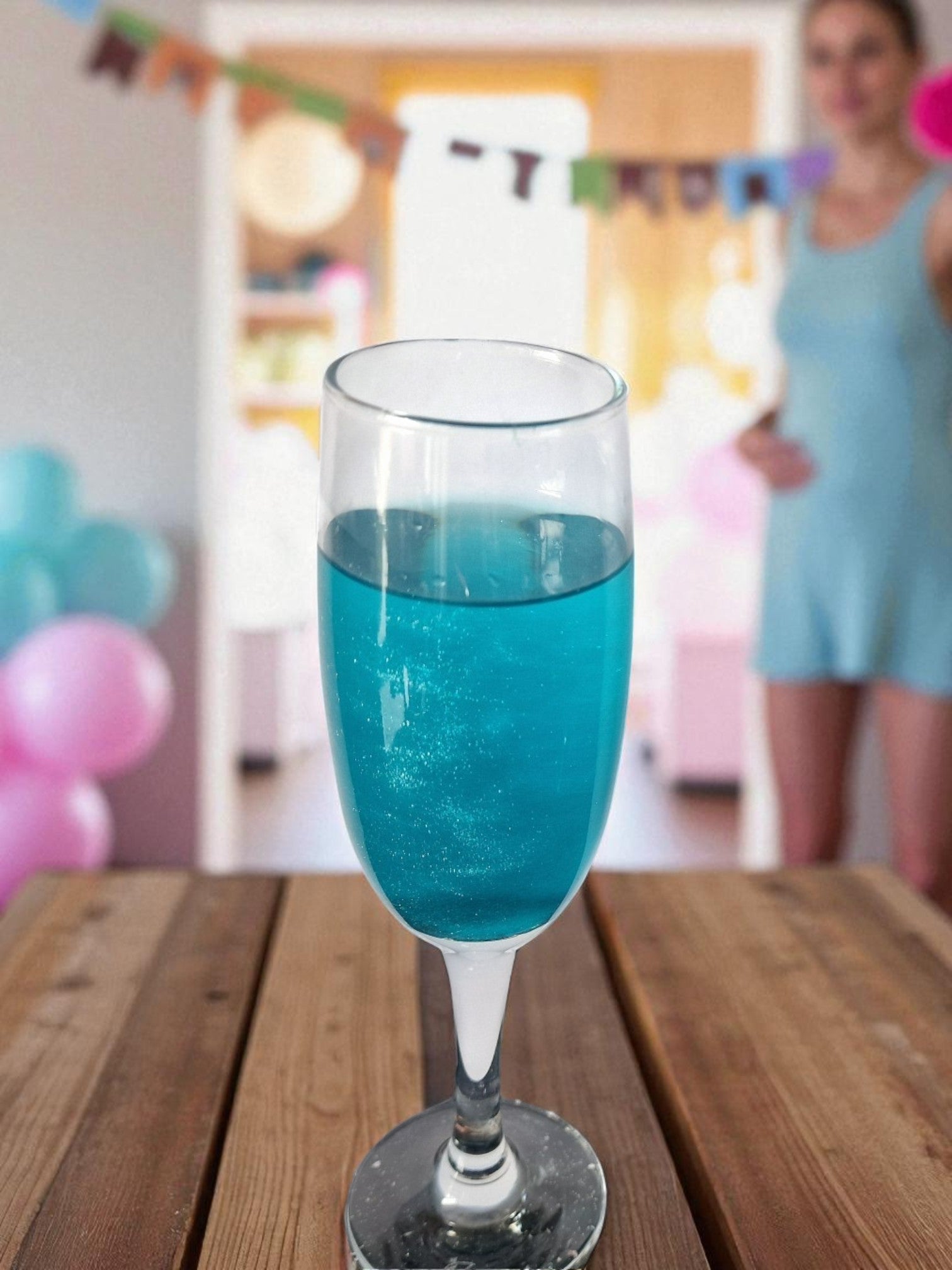 Two glasses of sparkling drinks—one blue, one pink—on a table with two white shimmer candy floss drink bombs in gold domes, perfect for gender reveal parties