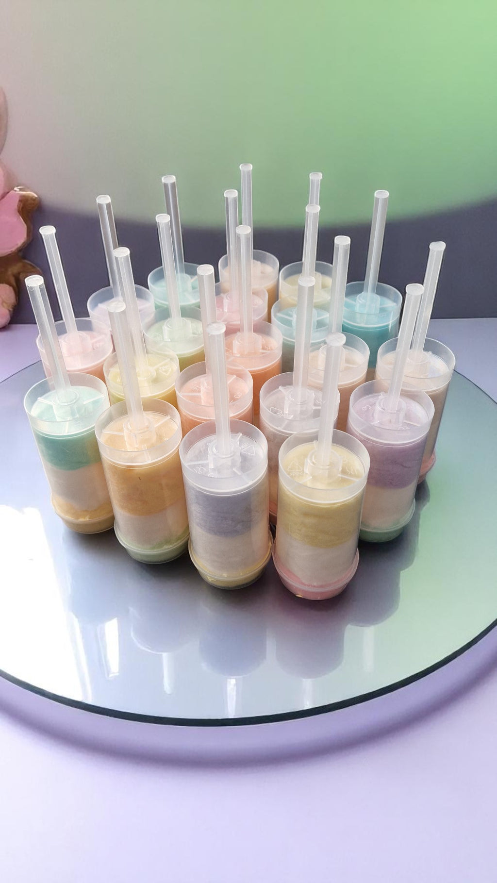 Ten personalised candy floss push pops in clear tubes with custom labels, displayed on a party table with colourful decorations—perfect for kids or adults