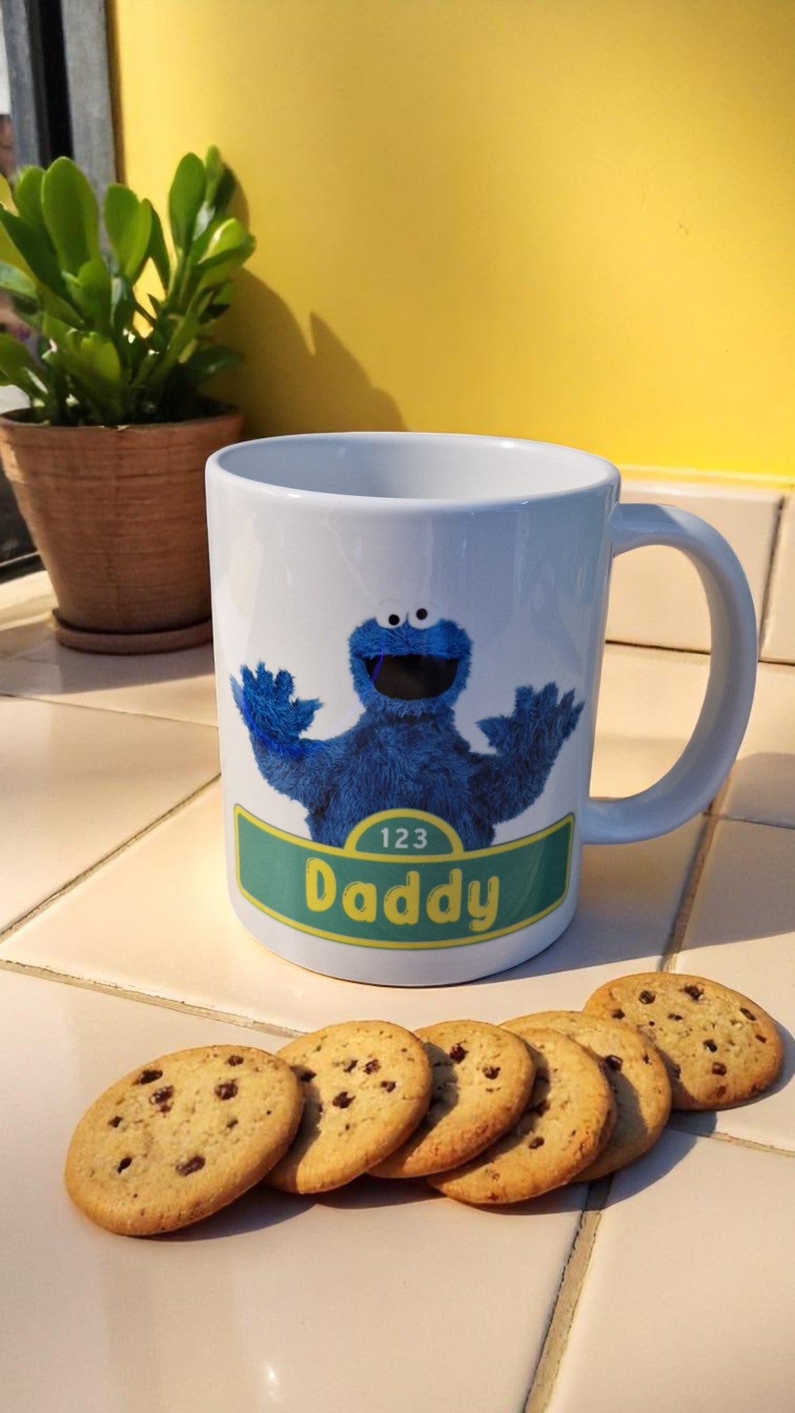 Mug with a character design and cookies on a tiled surface