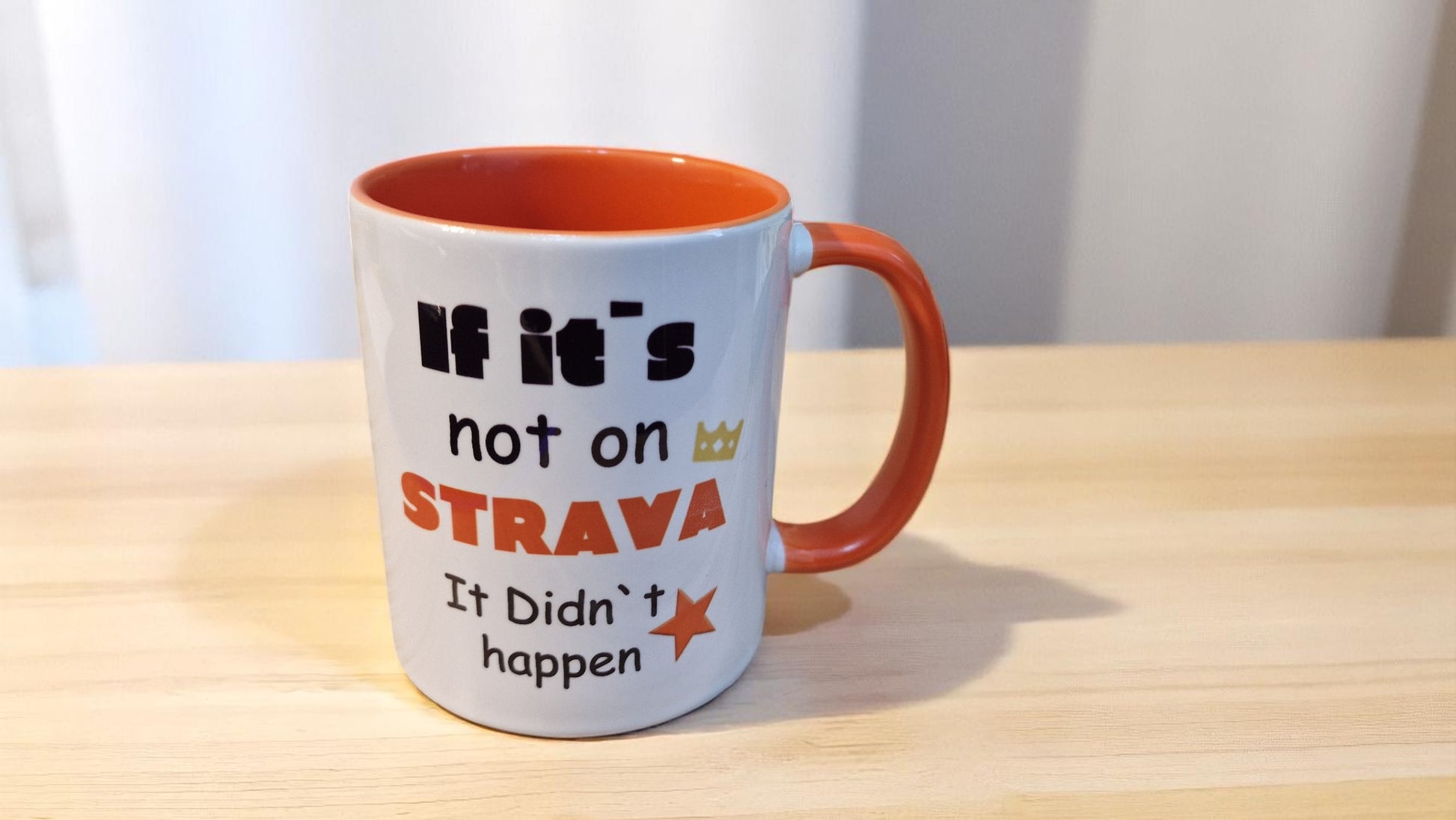 Mug with text 'If it's not on Strava, it didn't happen' on a wooden surface.