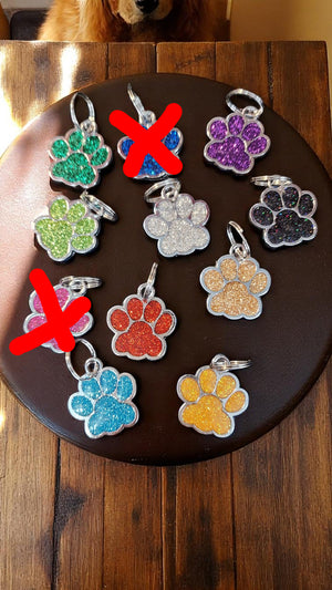 Colorful paw-shaped keychains on a dark surface