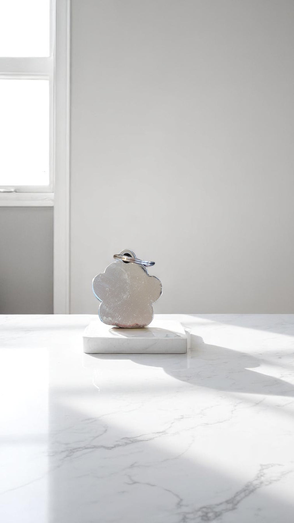 White marble sculpture on a white surface with a light gray wall in the background