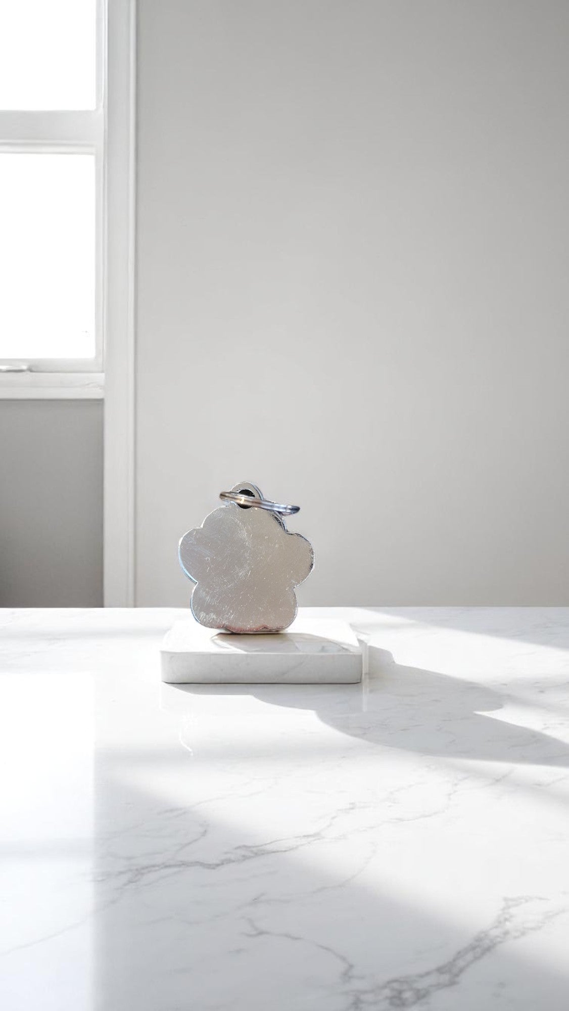 White marble sculpture on a white surface with a light gray wall in the background
