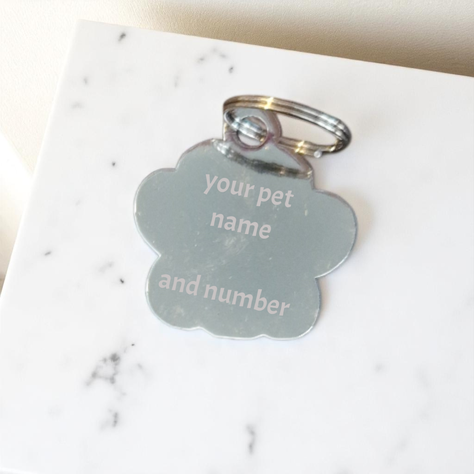 Pet tag with customizable text on a marble surface