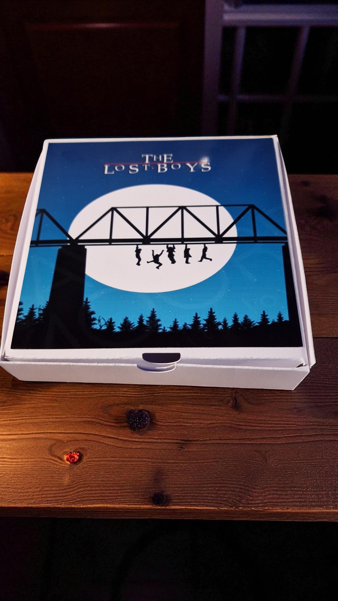 Board game box titled 'The Lost Boys' on a wooden surface