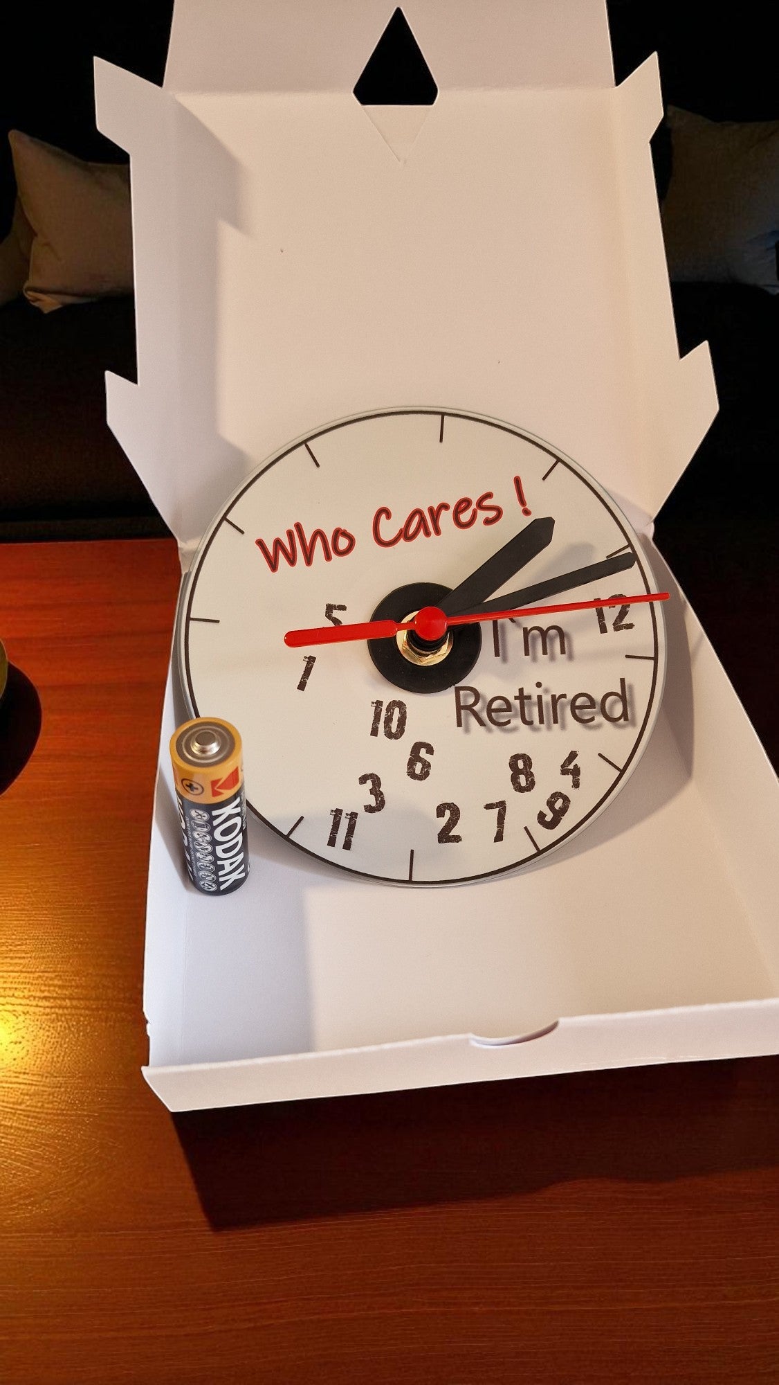 Clock with humorous message 'Who Cares! I'm Retired' on a white background