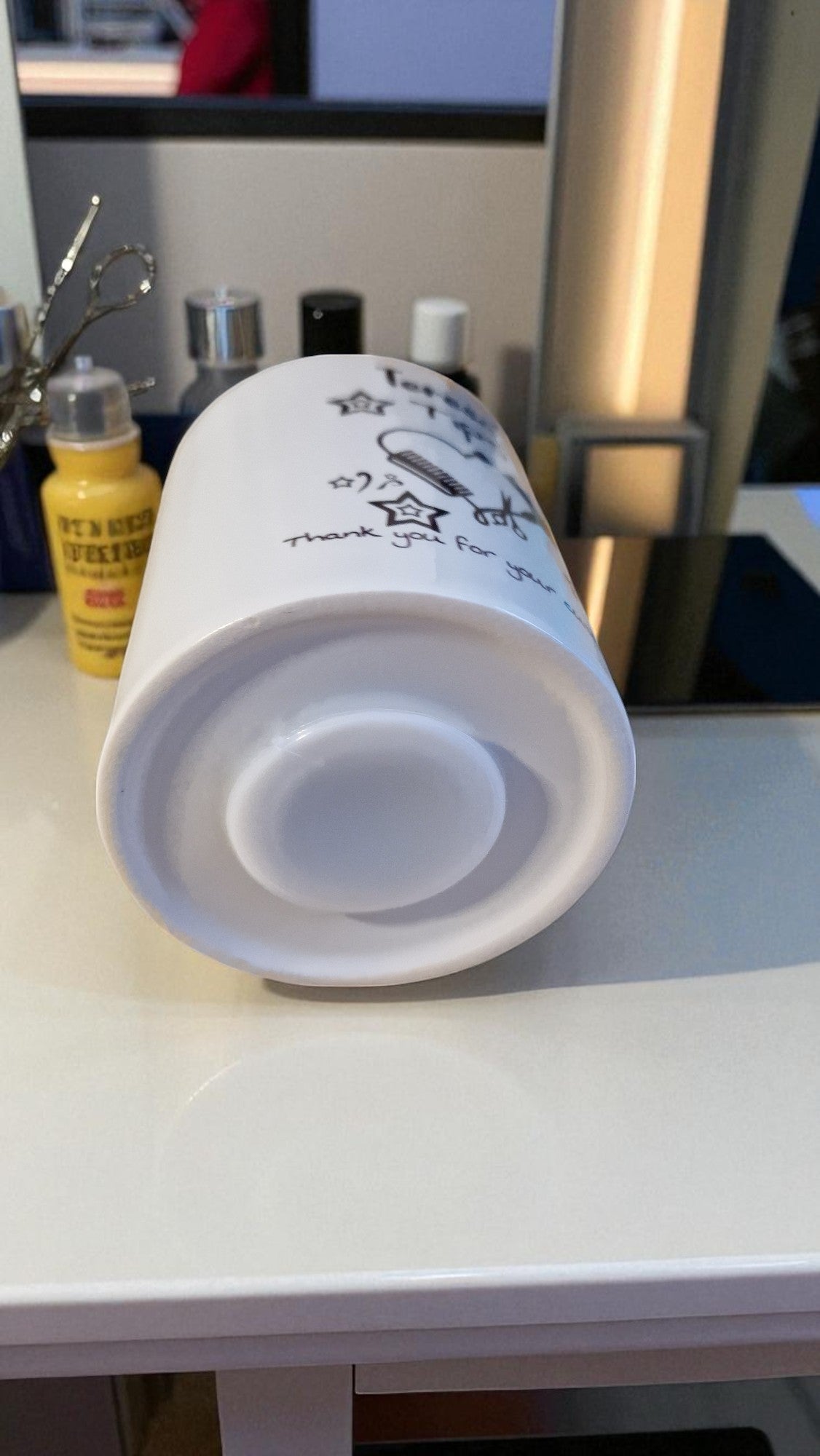 White cylindrical container with text on a white surface