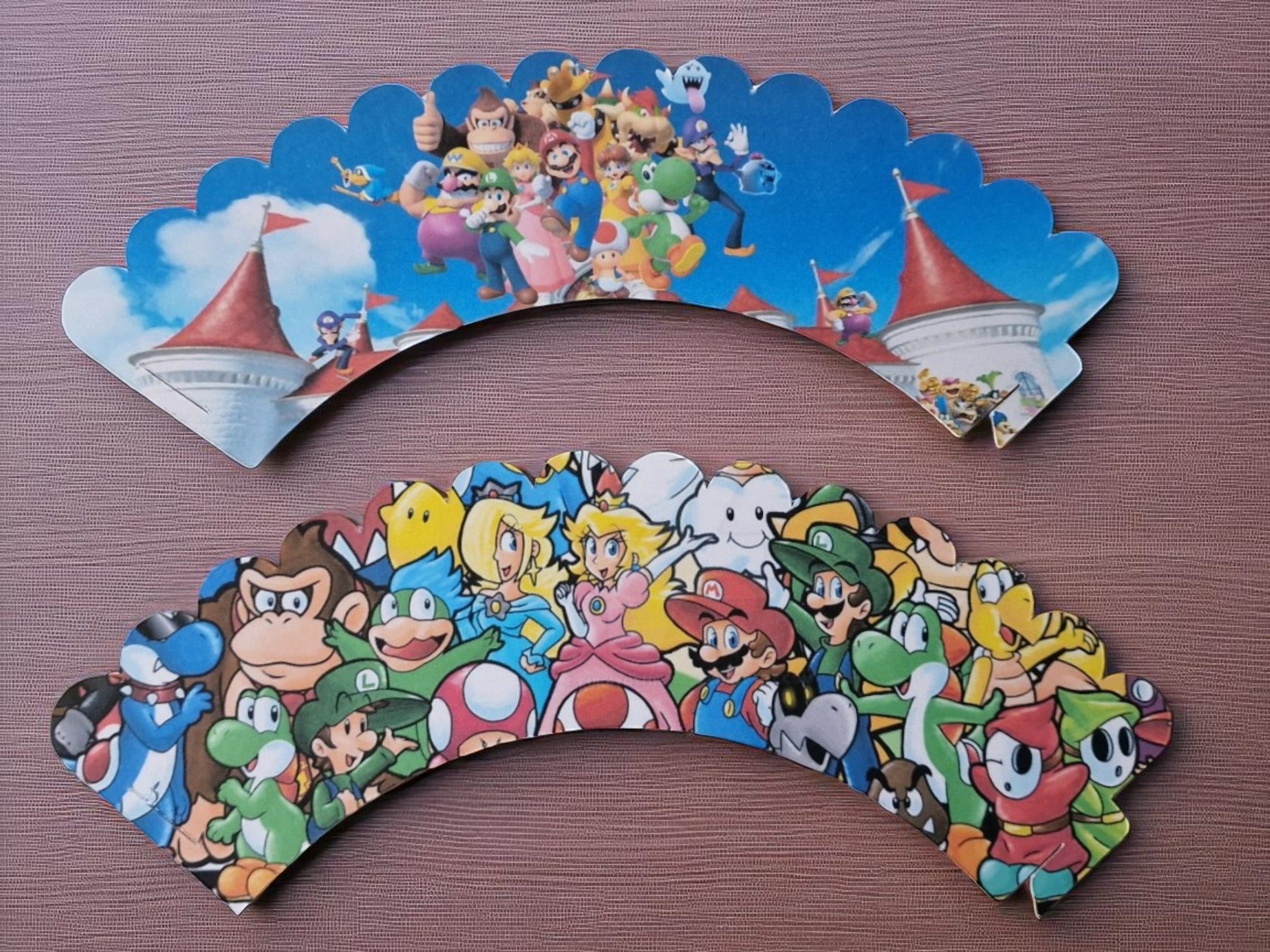 Set of 12 Mario cupcake wrappers in two designs, made from pre-cut cardstock, shown flat and assembled for birthday party decoration. Not edible."