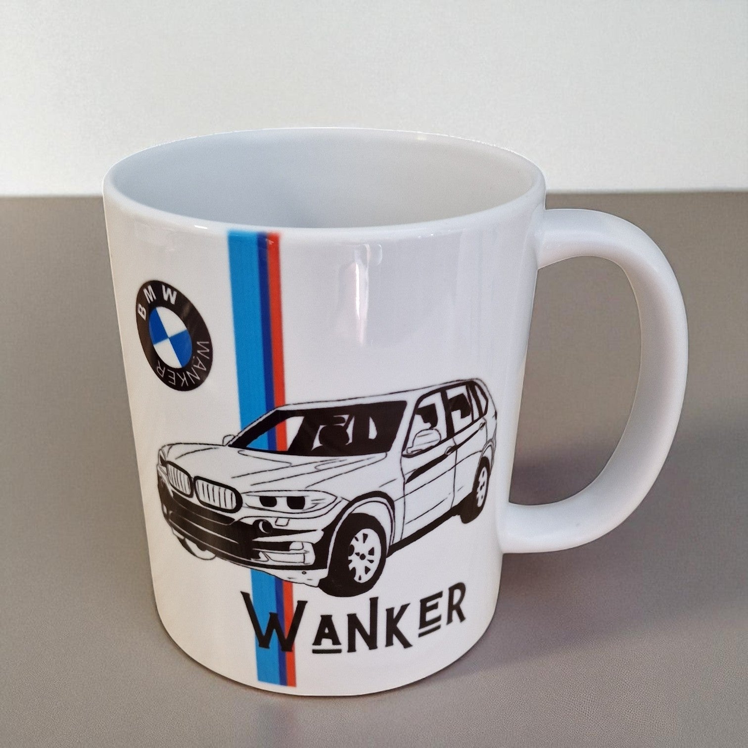 White mug with BMW logo and car illustration on a gray surface