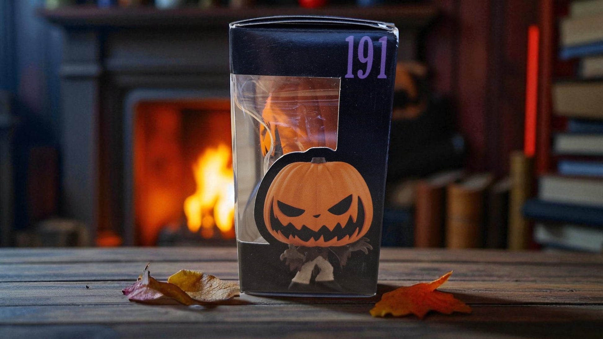 Glass container with a pumpkin design and number 191 on a wooden surface with a fireplace in the background.