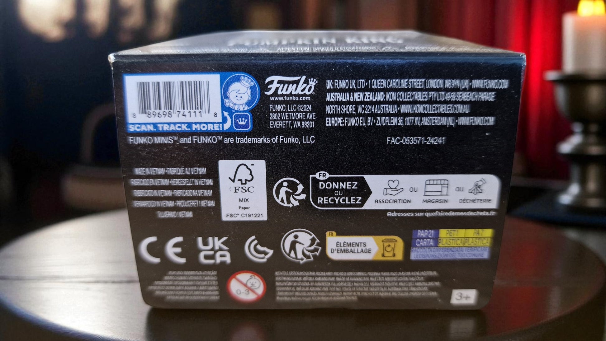 Back of a Funko product box with various logos and text on a reflective surface.
