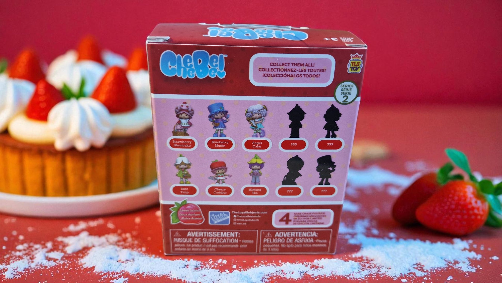 CleoPet toy packaging with toy figures on a red background with a cake and strawberries.