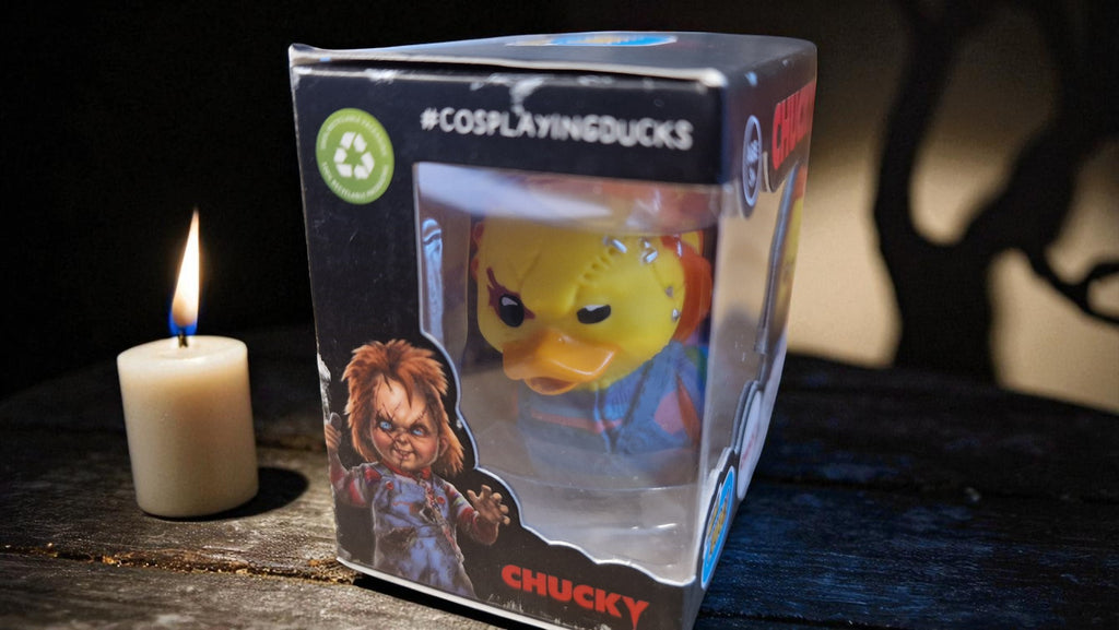 Boxed Chucky figurine with a candle on a dark surface