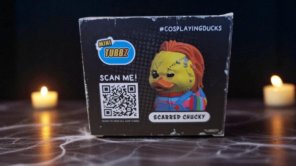 Mini Tubbz figurine packaging with QR code on a dark surface with candles