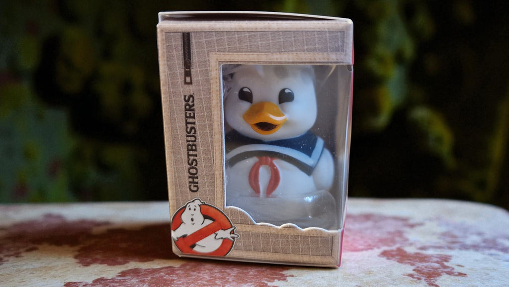 Ghostbusters-themed figurine in packaging on a floral-patterned surface