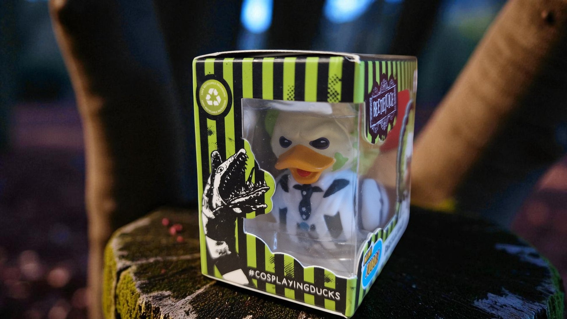 Toy duck in a box with a striped design on a dark background