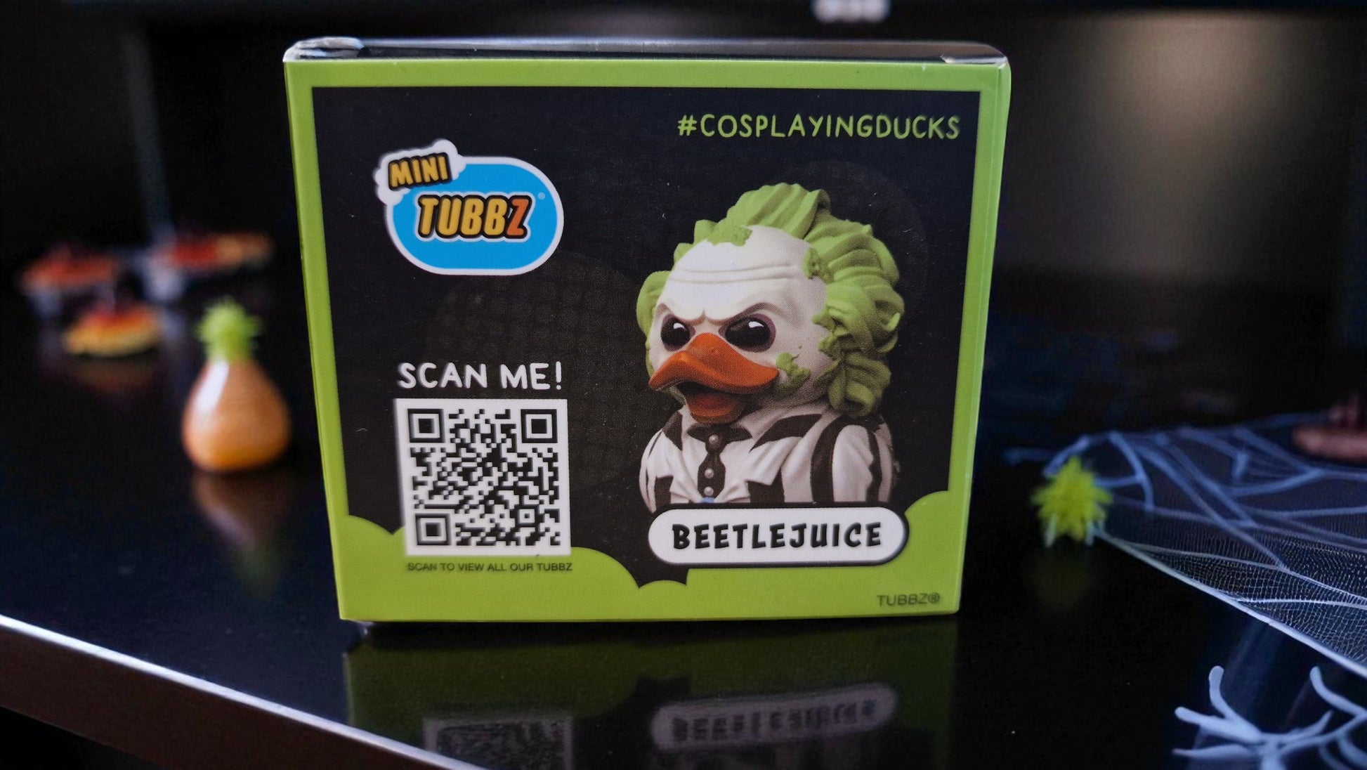 Box of a 'Beetlejuice' themed product with a QR code on a dark surface.
