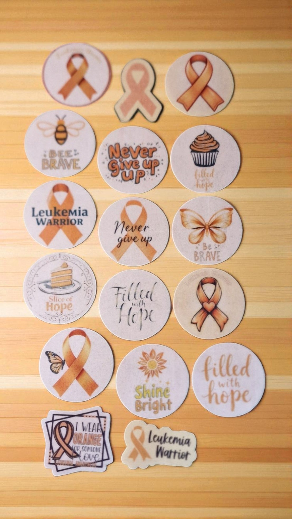 Fifteen orange leukemia awareness ribbon edible cake toppers, pre-cut and arranged on a white background, suitable for all dietary needs.