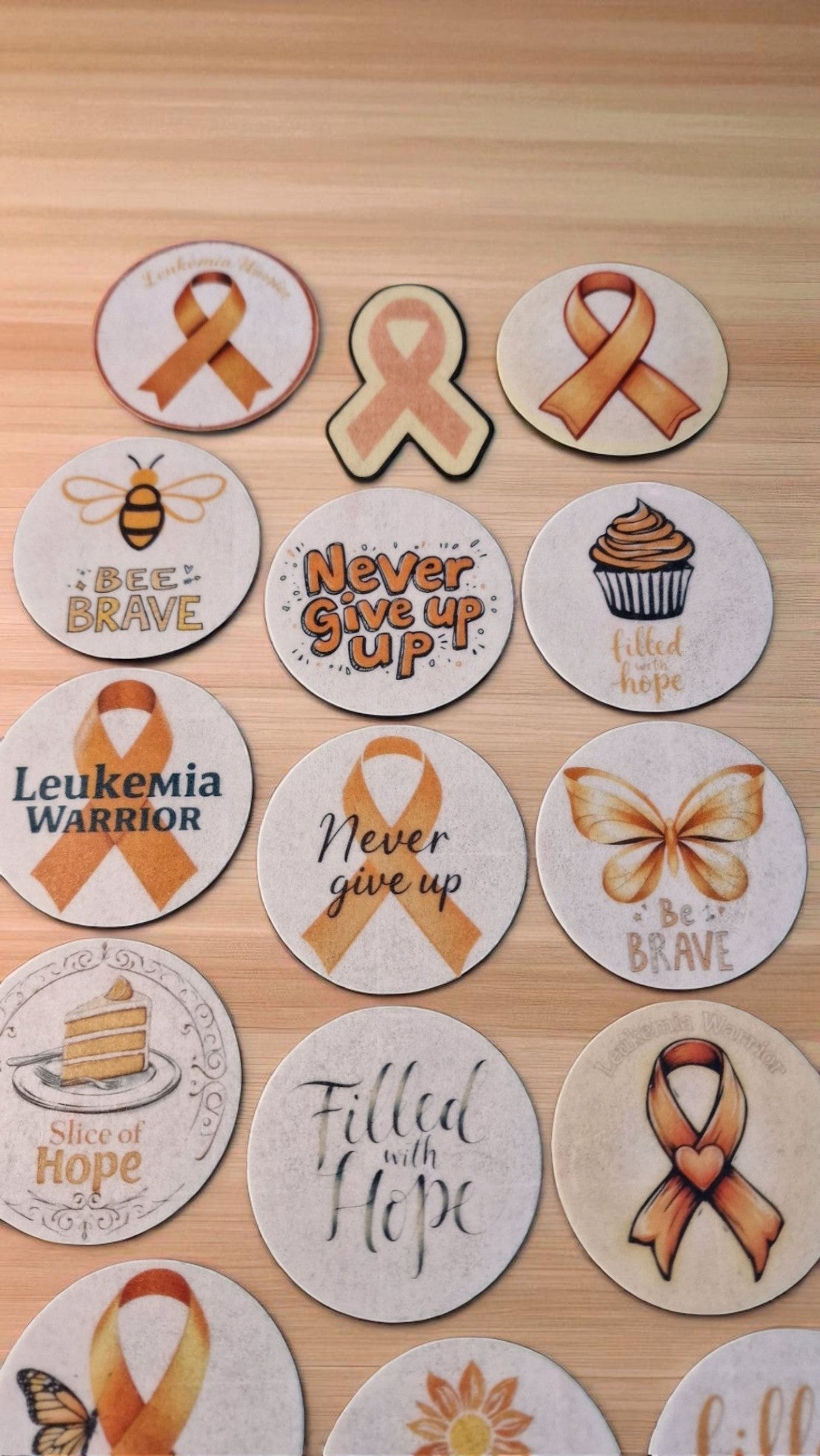Fifteen orange leukemia awareness ribbon edible cake toppers, pre-cut and arranged on a white background, suitable for all dietary needs.