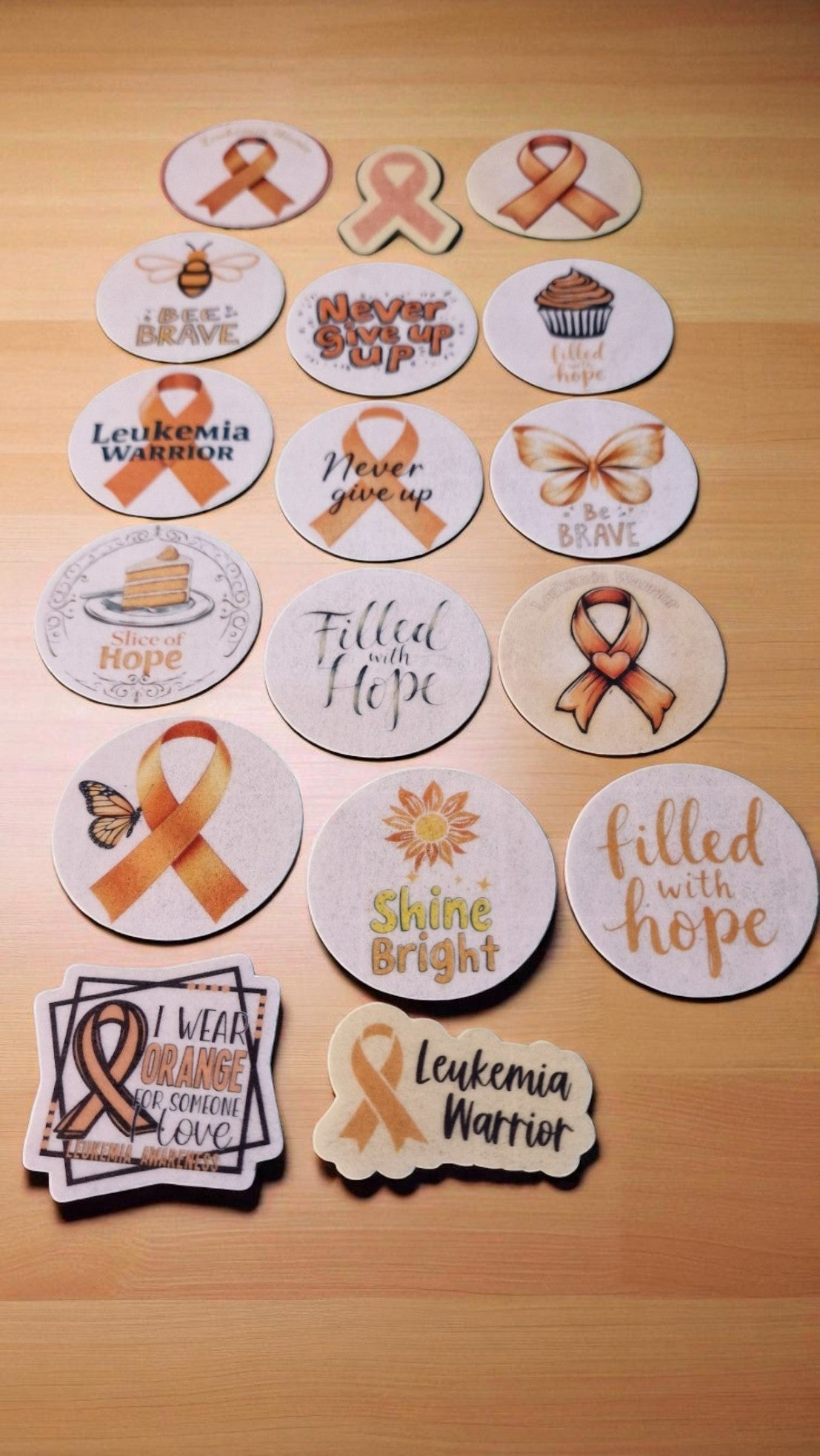 Fifteen orange leukemia awareness ribbon edible cake toppers, pre-cut and arranged on a white background, suitable for all dietary needs.