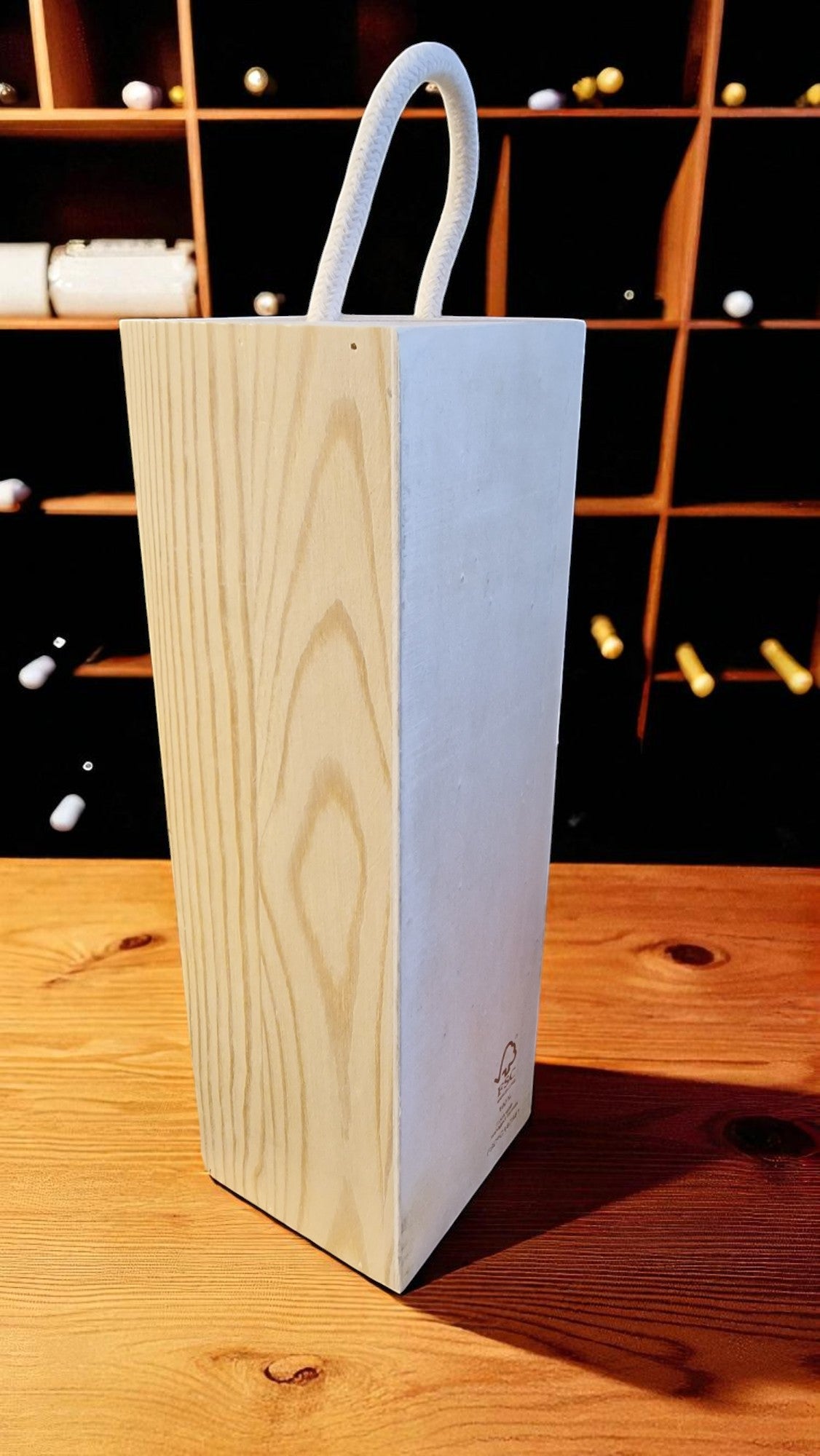 Wooden wine box with a white handle on a wooden surface