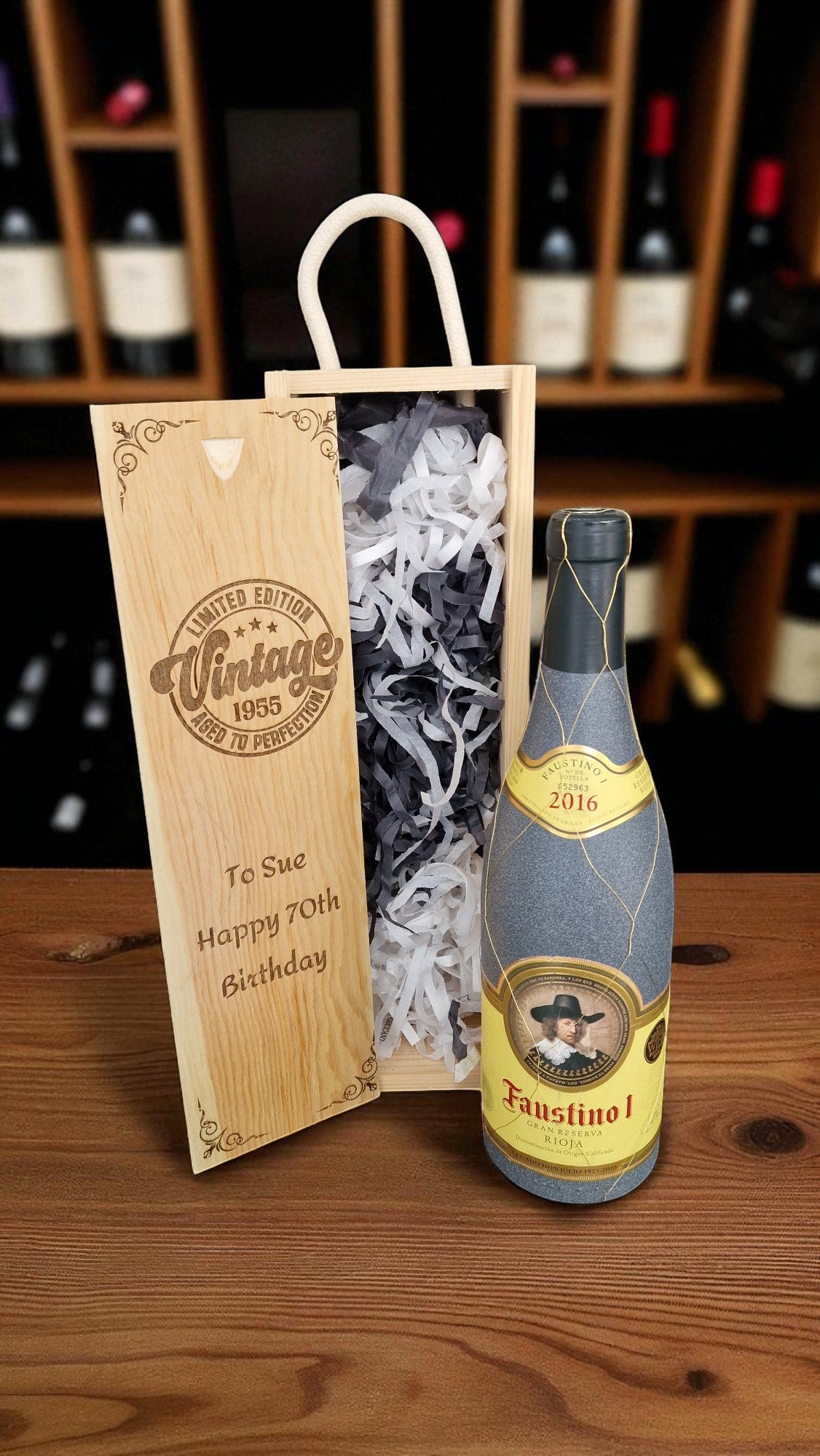 Wine bottle with wooden gift box and decorative paper on a wooden surface.