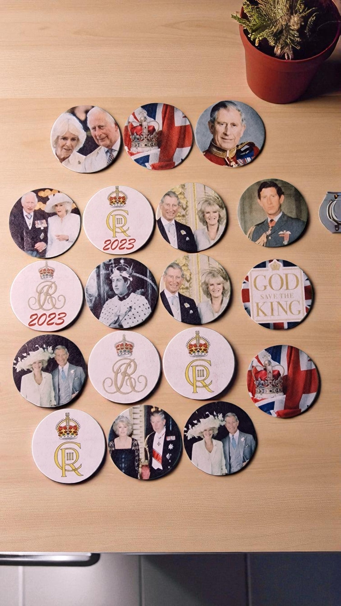 Collection of circular coasters featuring images of a royal family on a wooden surface.