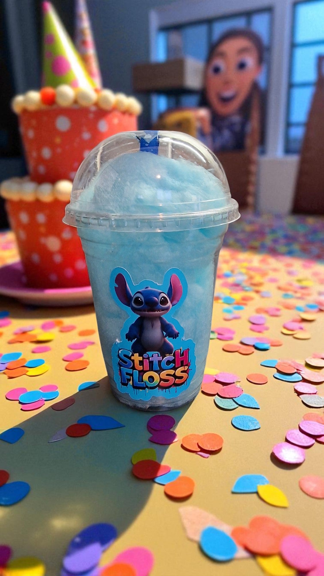 Blue slushy in a 'Stitch Floss' cup on a table with colorful confetti