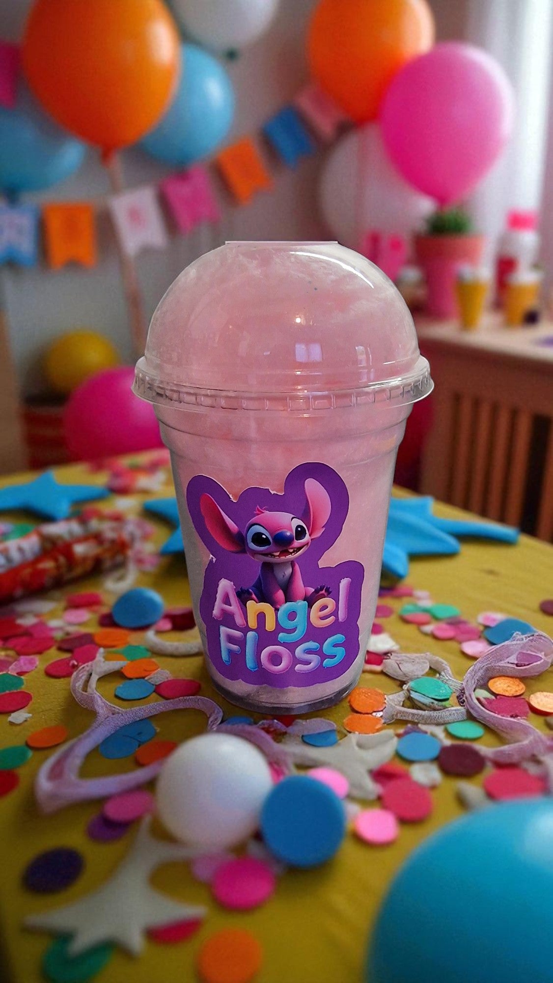 Pink cup labeled 'Angel Floss' with colorful balloons and confetti in the background