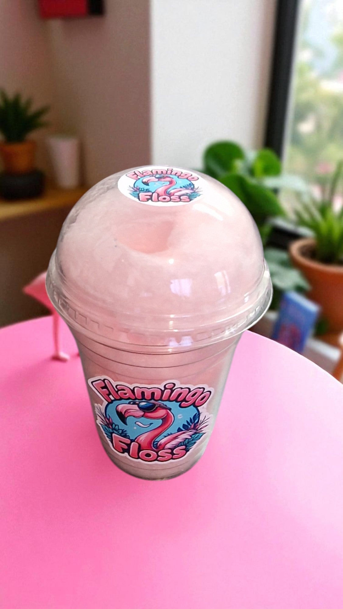 Pink slushy drink in a cup with 'Flamingo Floss' branding on a pink surface.