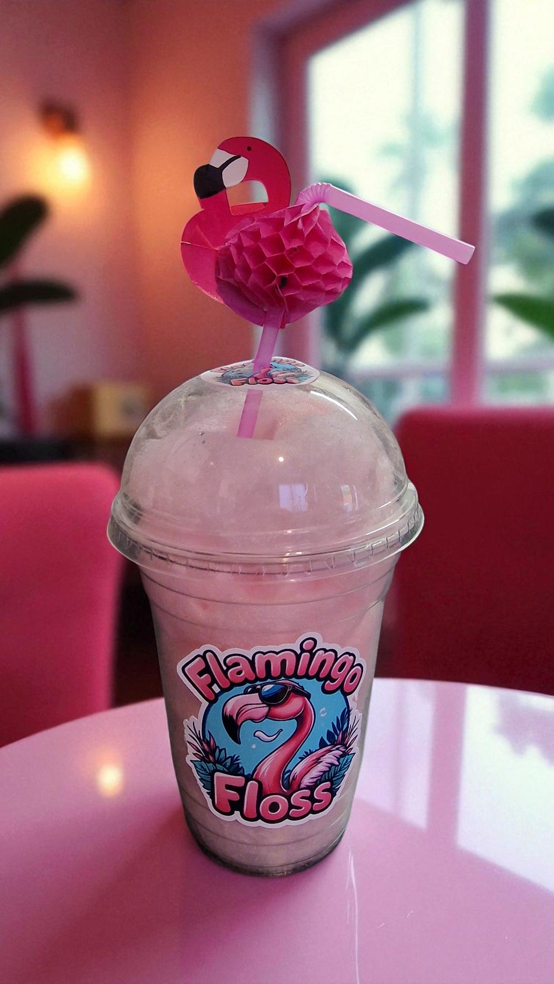 Pink drink with flamingo-themed cup and straw on a pink table