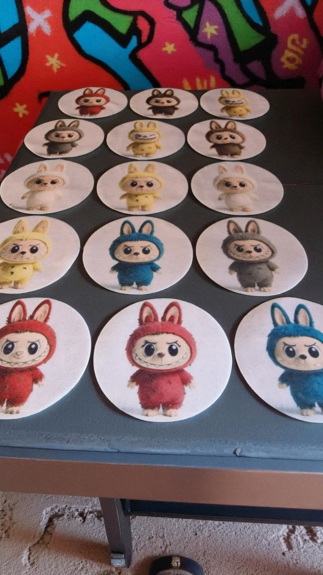 Circular stickers with cartoon characters on a flat surface.