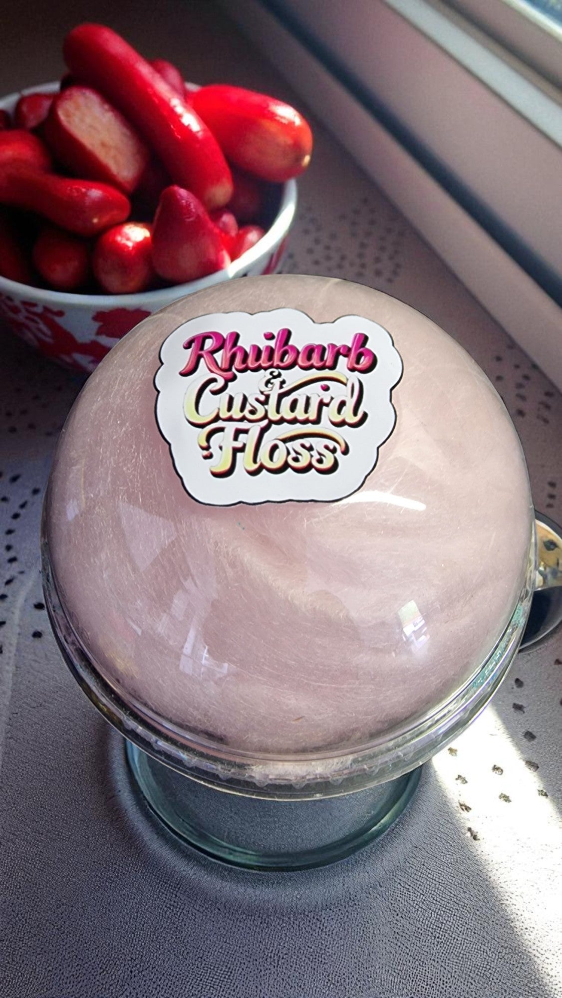 Jar of Rhubarb Custard Floss with a bowl of rhubarb in the background