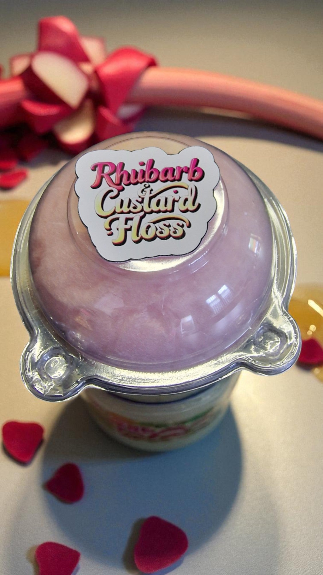 Jar of Rhubarb Custard Floss with a decorative bow in the background