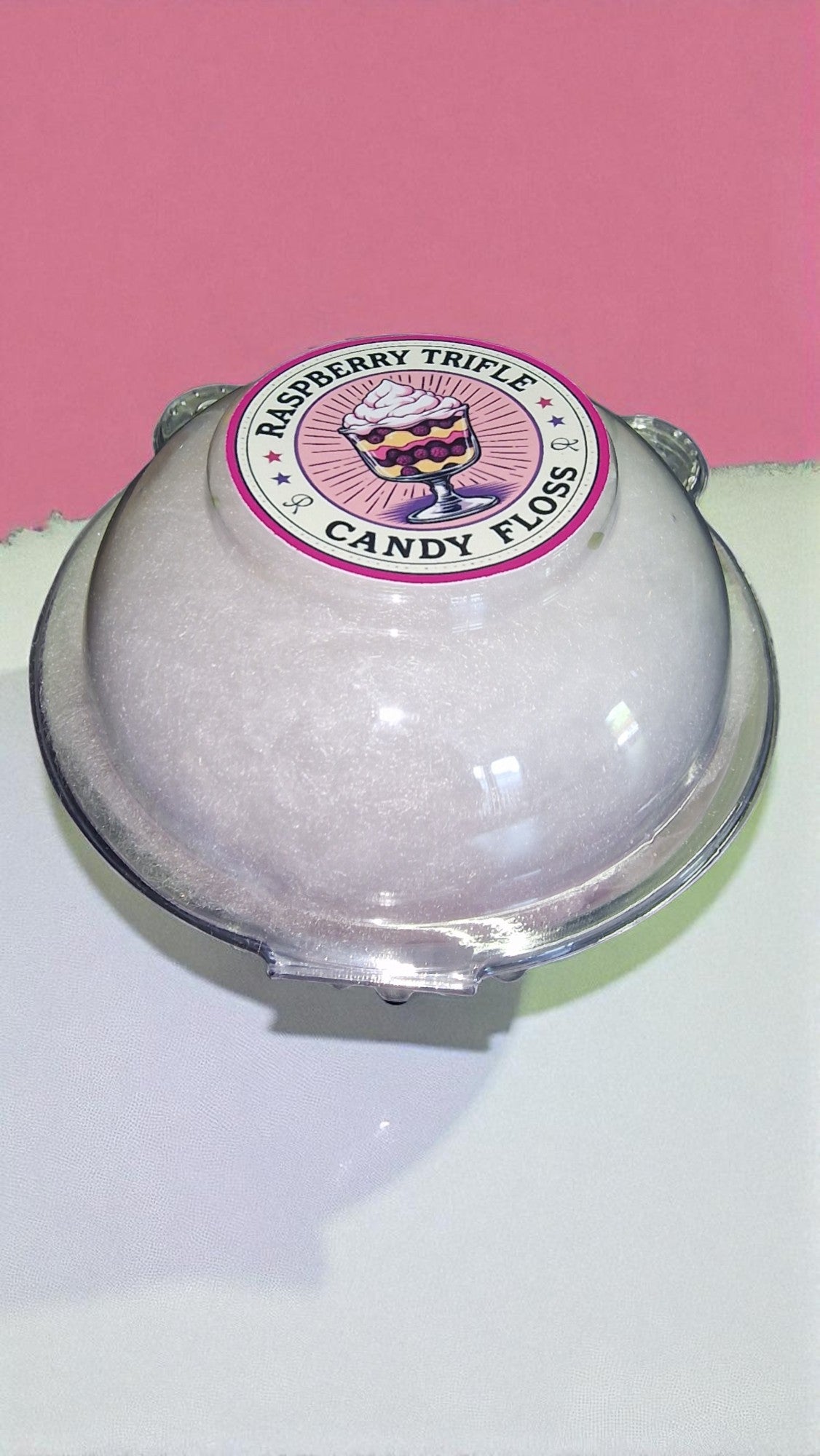 Candy floss container with raspberry truffle flavor label on a pink background