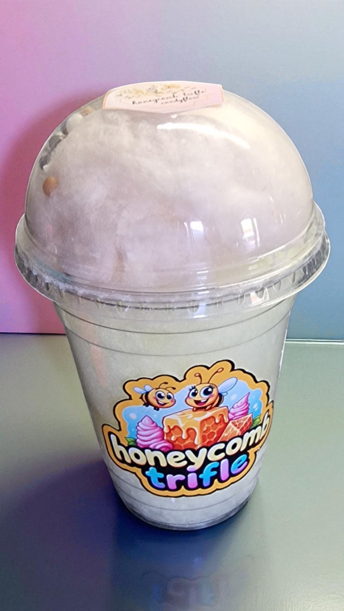 Ice cream dessert in a transparent cup with a colorful logo on a light blue background