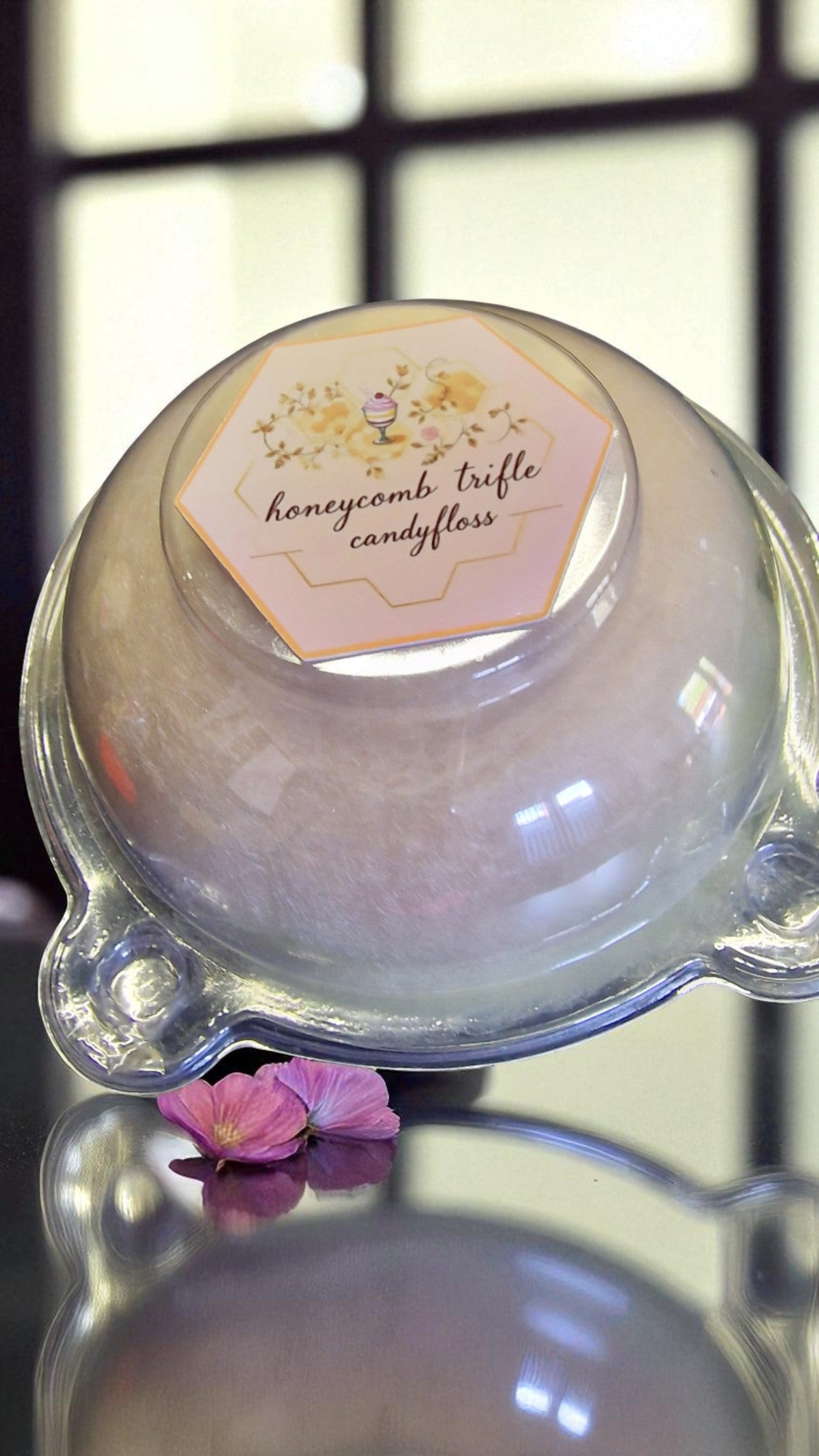 Glass dome with a pink honeycomb trifle candyfloss inside, labeled 'honeycomb trifle candyfloss'.