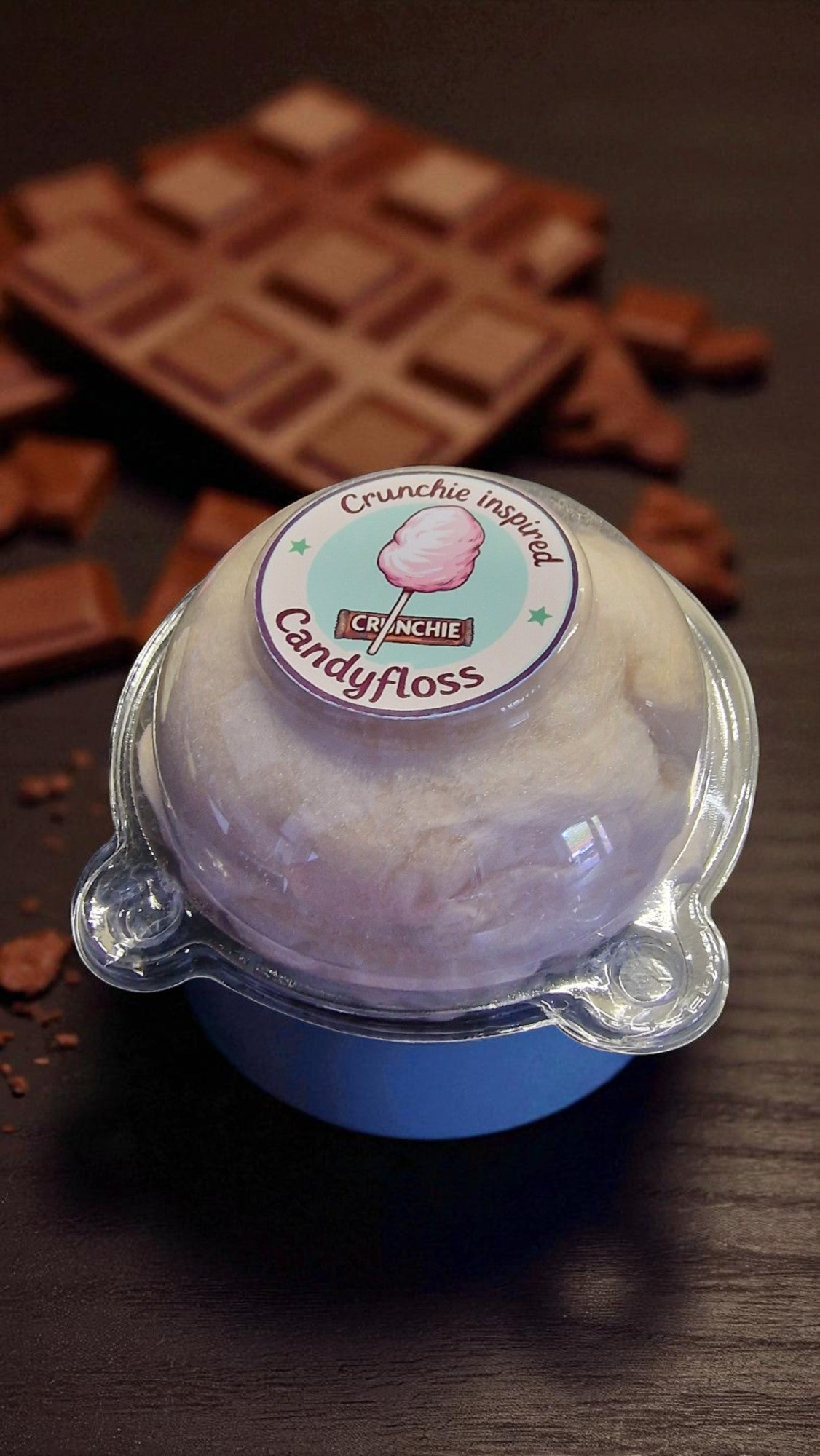Bowl of candyfloss with a Crunchie inspired label on a dark surface with chocolate bars.