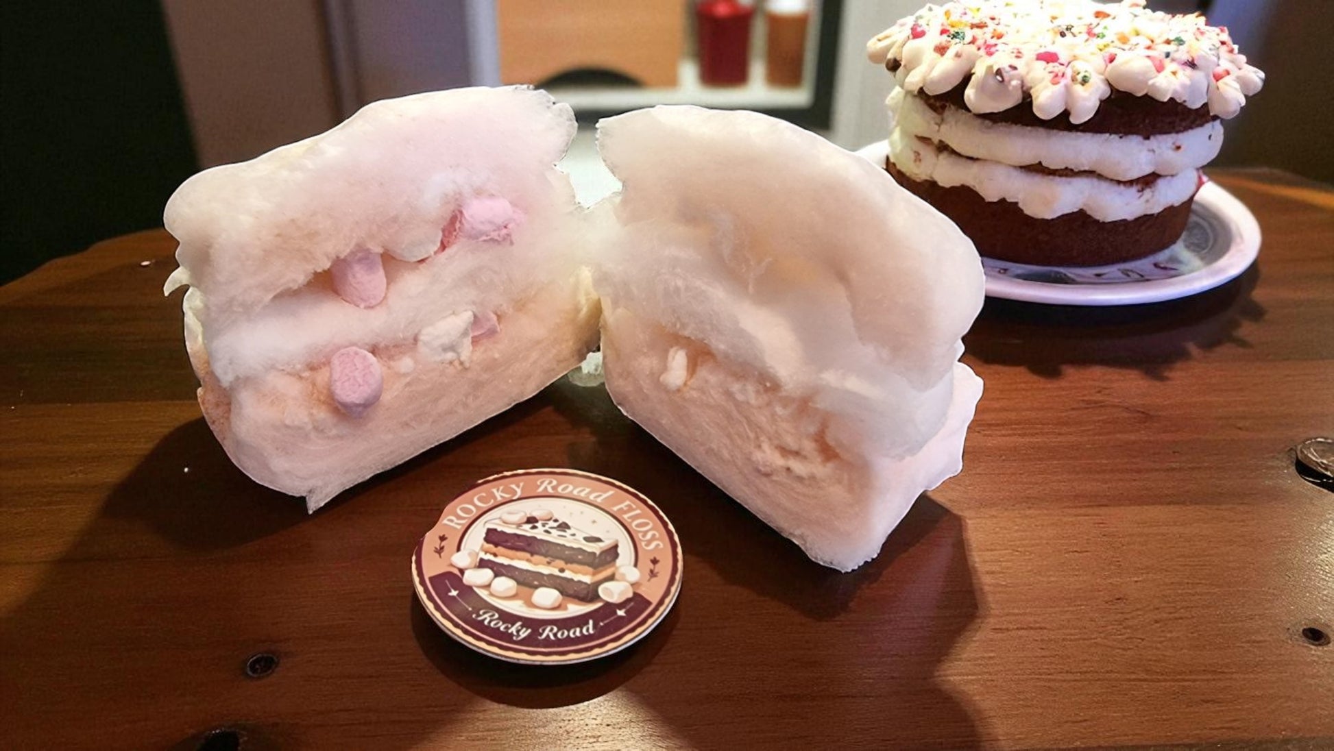Sliced marshmallow dessert on a wooden table with a branded coaster.