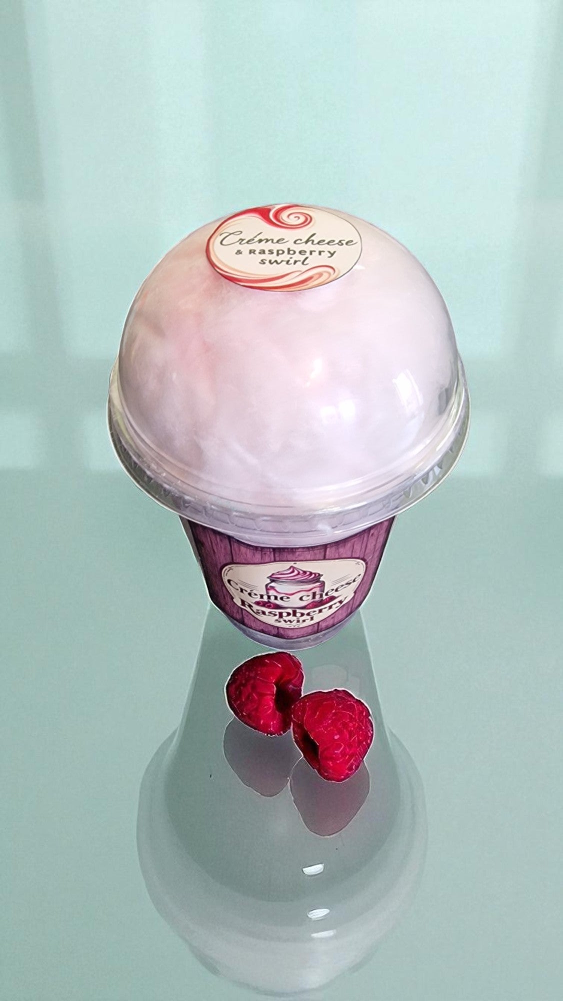 Pink dessert ball with raspberry on a light blue background