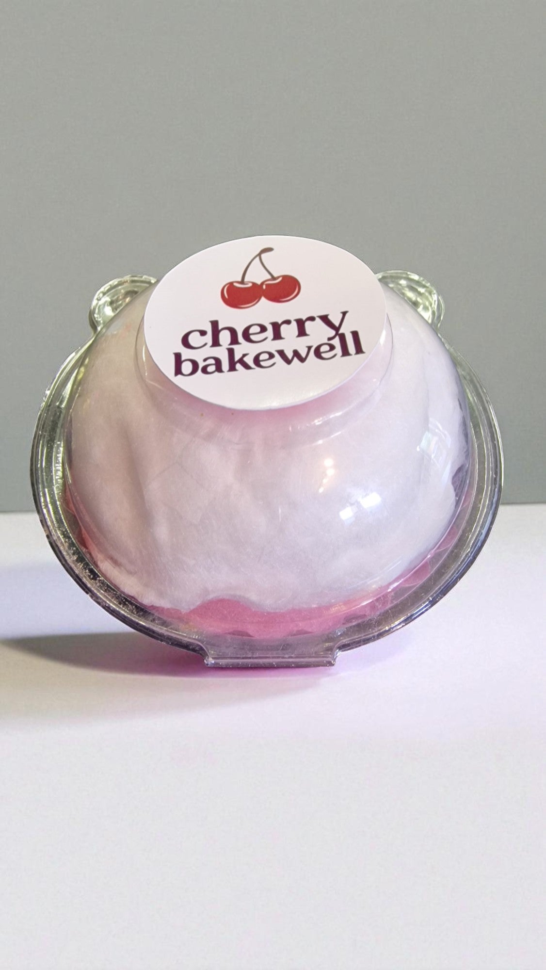 Cherry Bakewell product in a clear container with a white label on a light gray background
