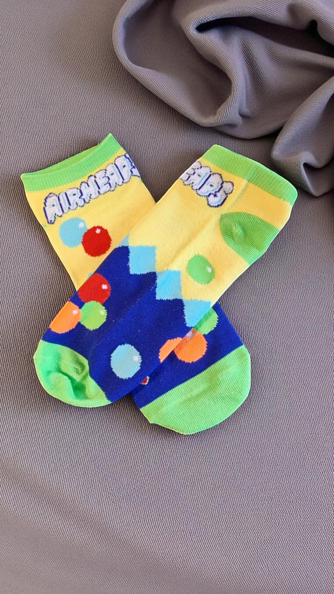 Colorful socks with a cartoon character on a gray surface