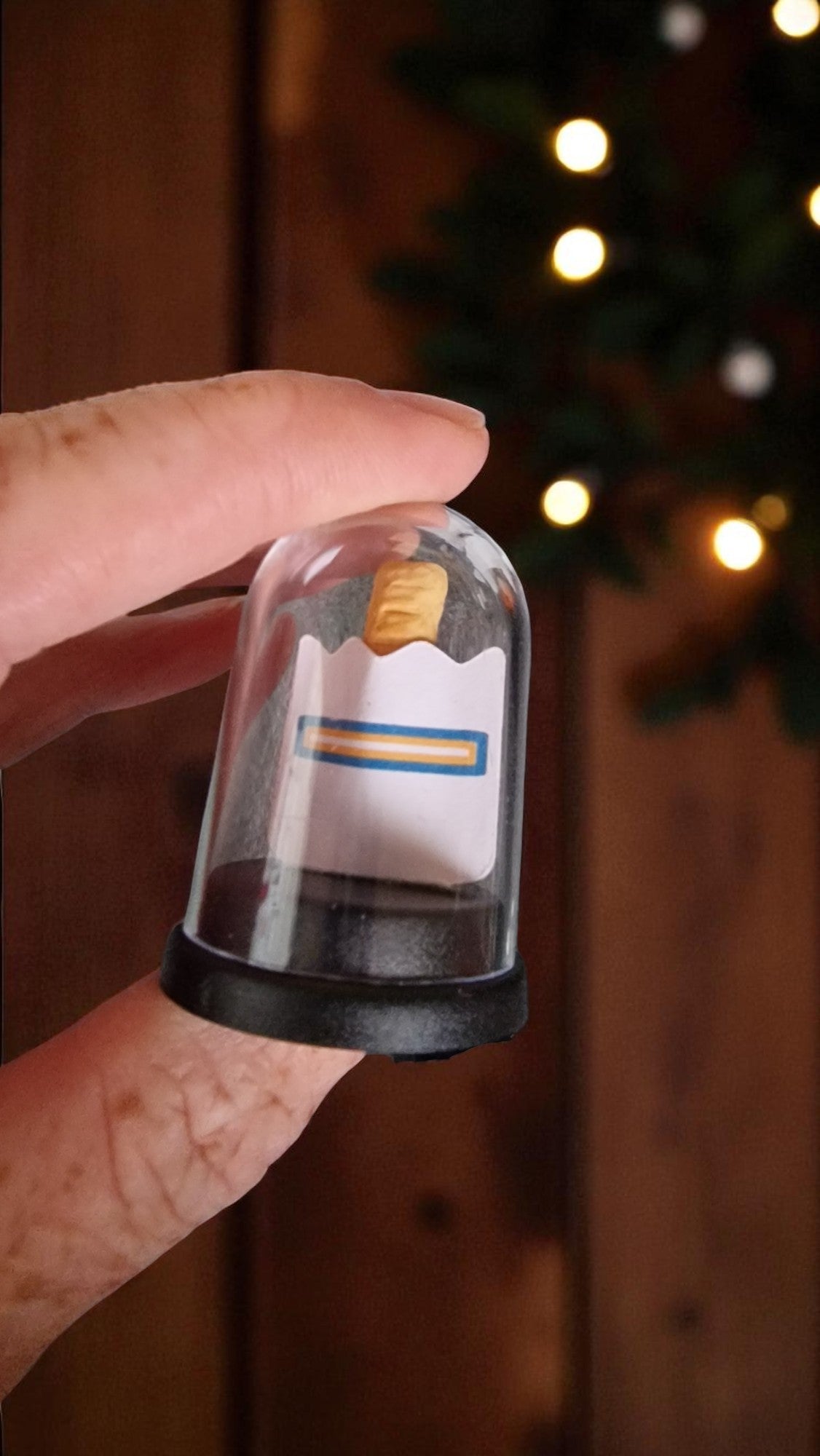 Small bottle with a yellow cap held by a hand against a blurred background