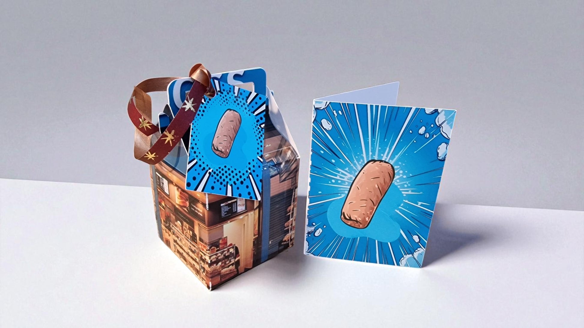 Cardboard box with a blue card featuring a bandage design on a white surface.