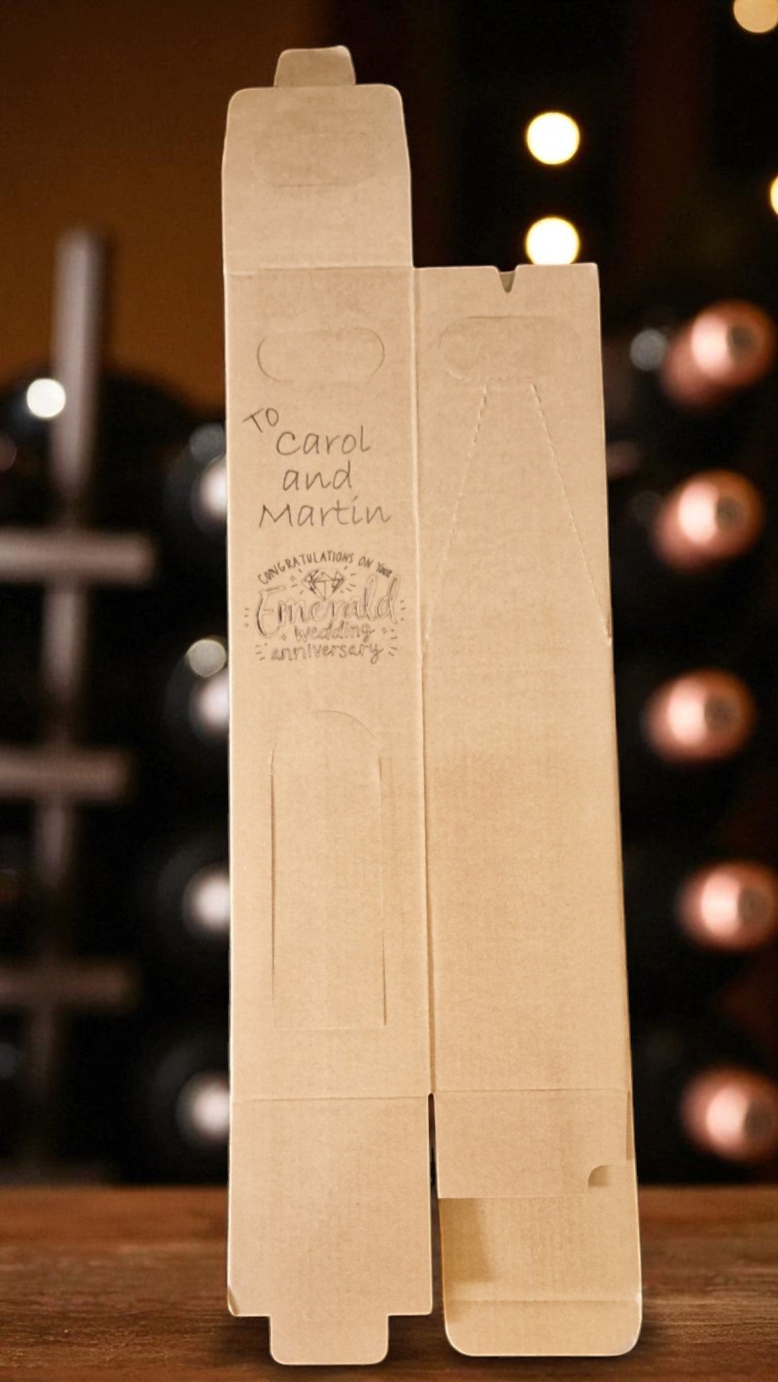 Wooden wine box with engraved text on a wooden surface with blurred lights in the background
