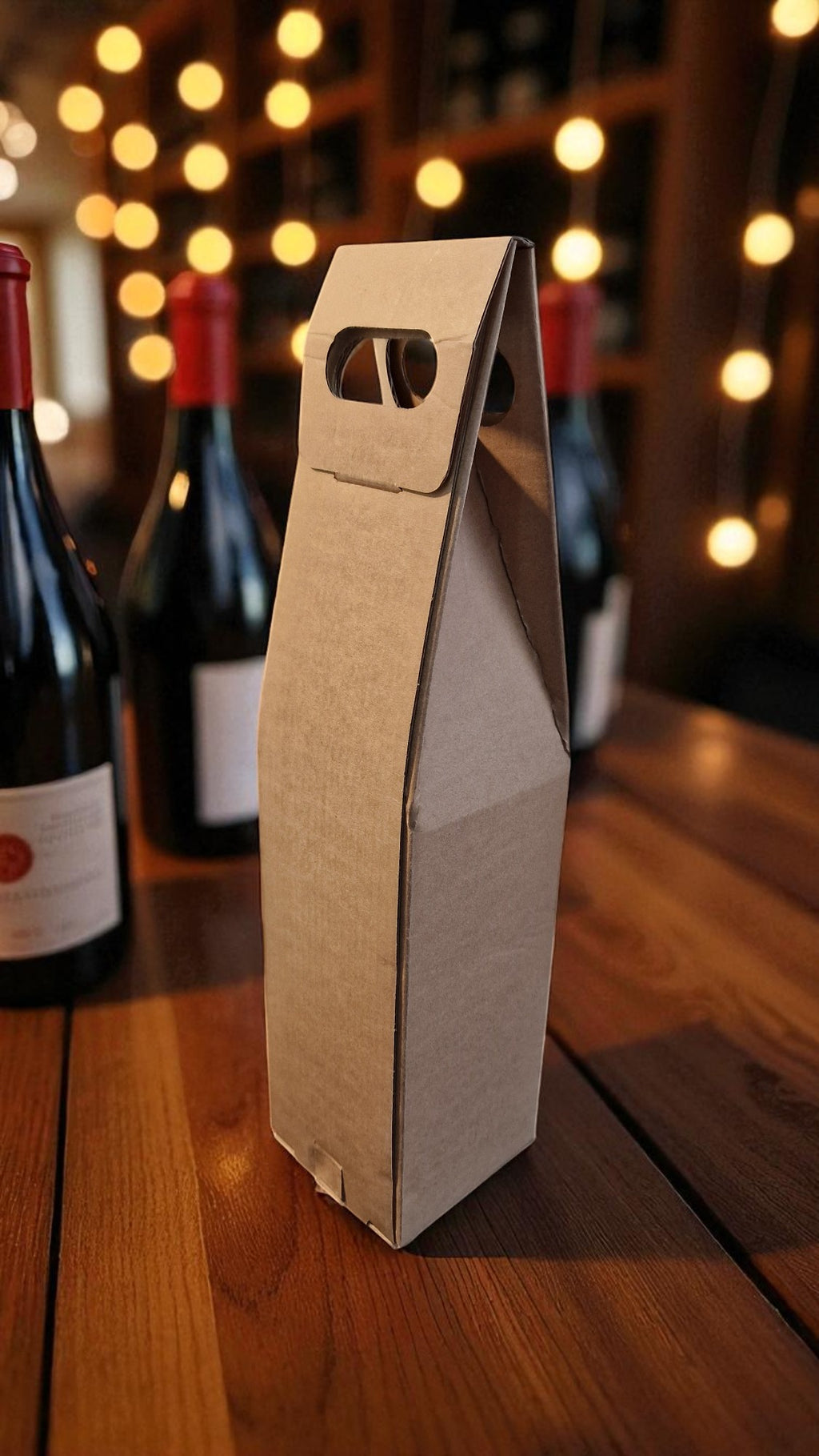 Cardboard wine bottle box on a wooden table with wine bottles in the background.