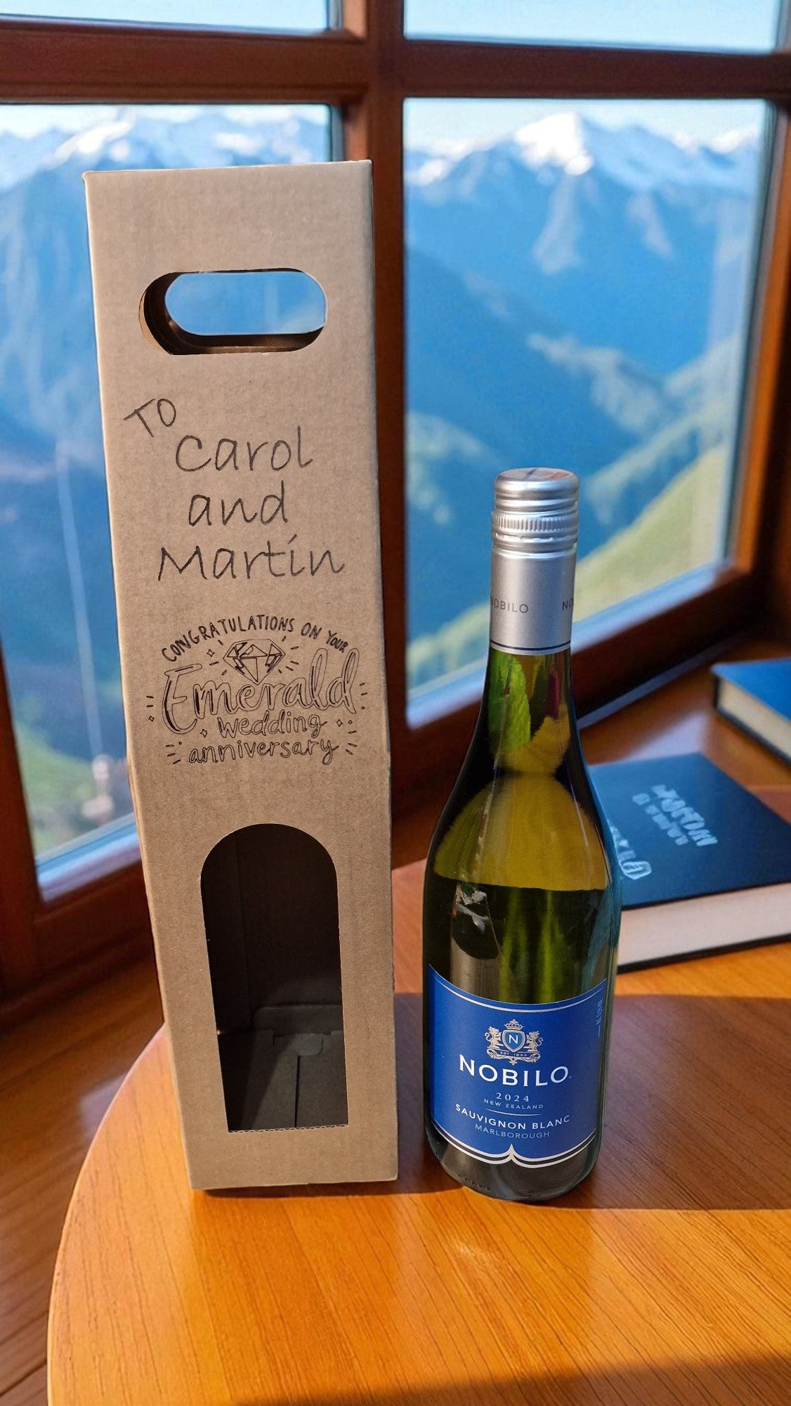 Nobilis wine bottle with a personalized box against a mountainous background