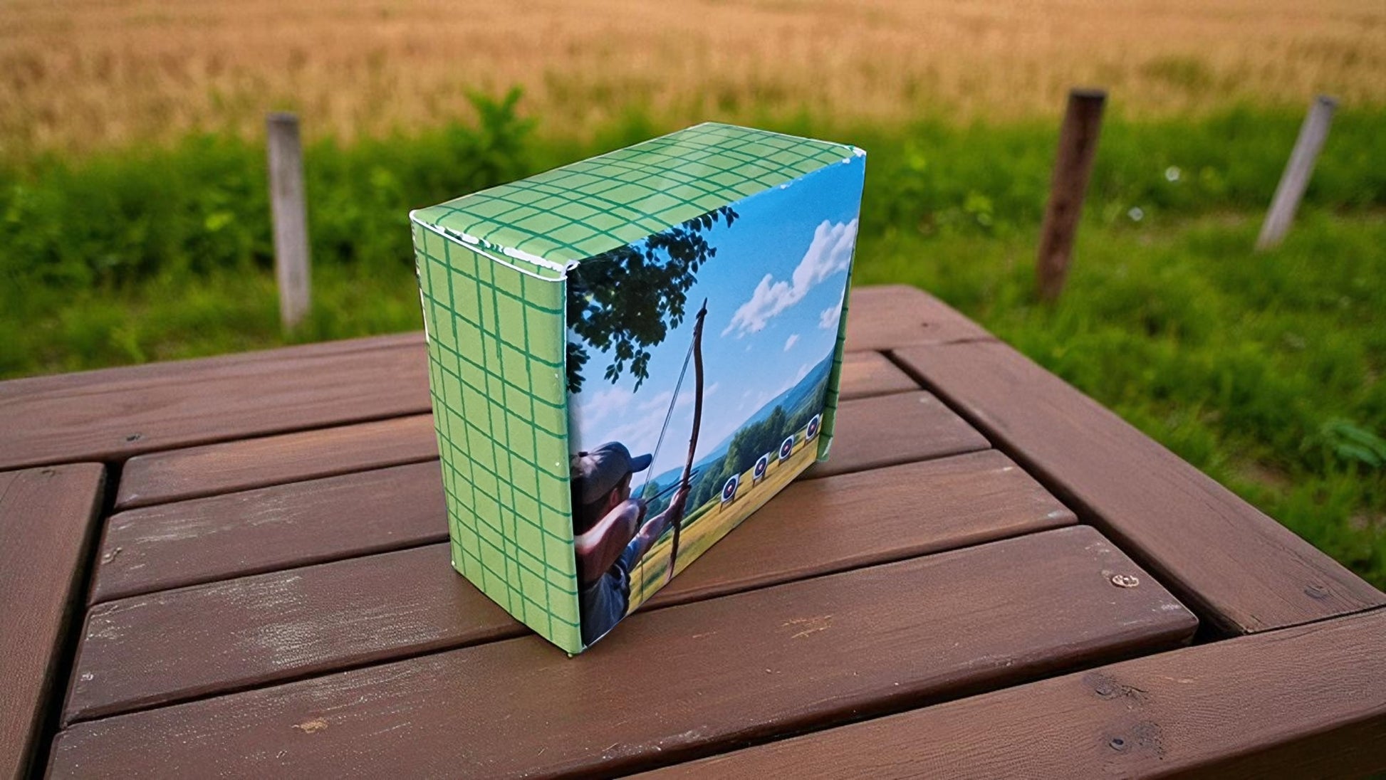 Box with a scenic design on a wooden table outdoors