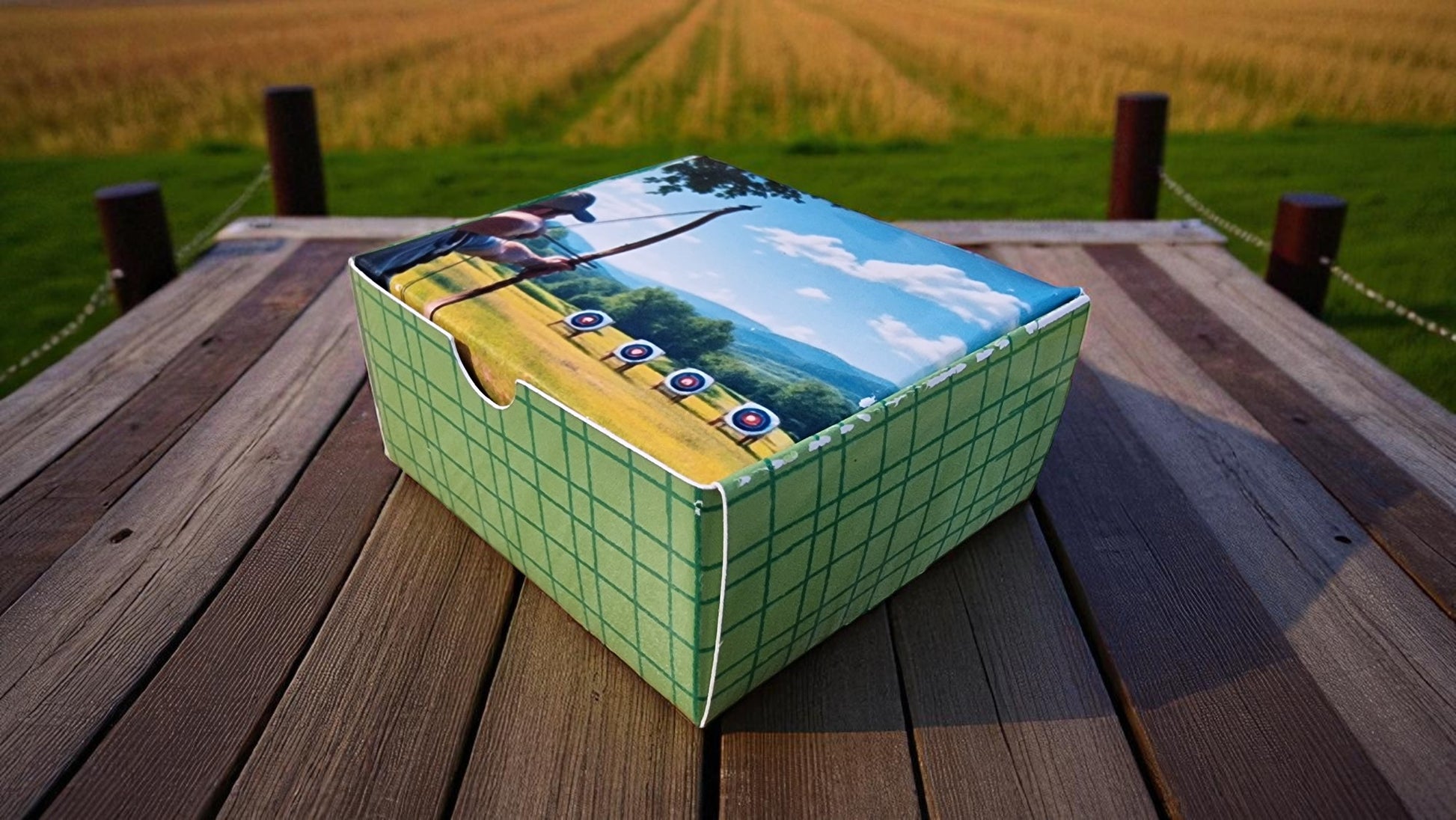 Cardboard box with scenic design on a wooden surface with a field background